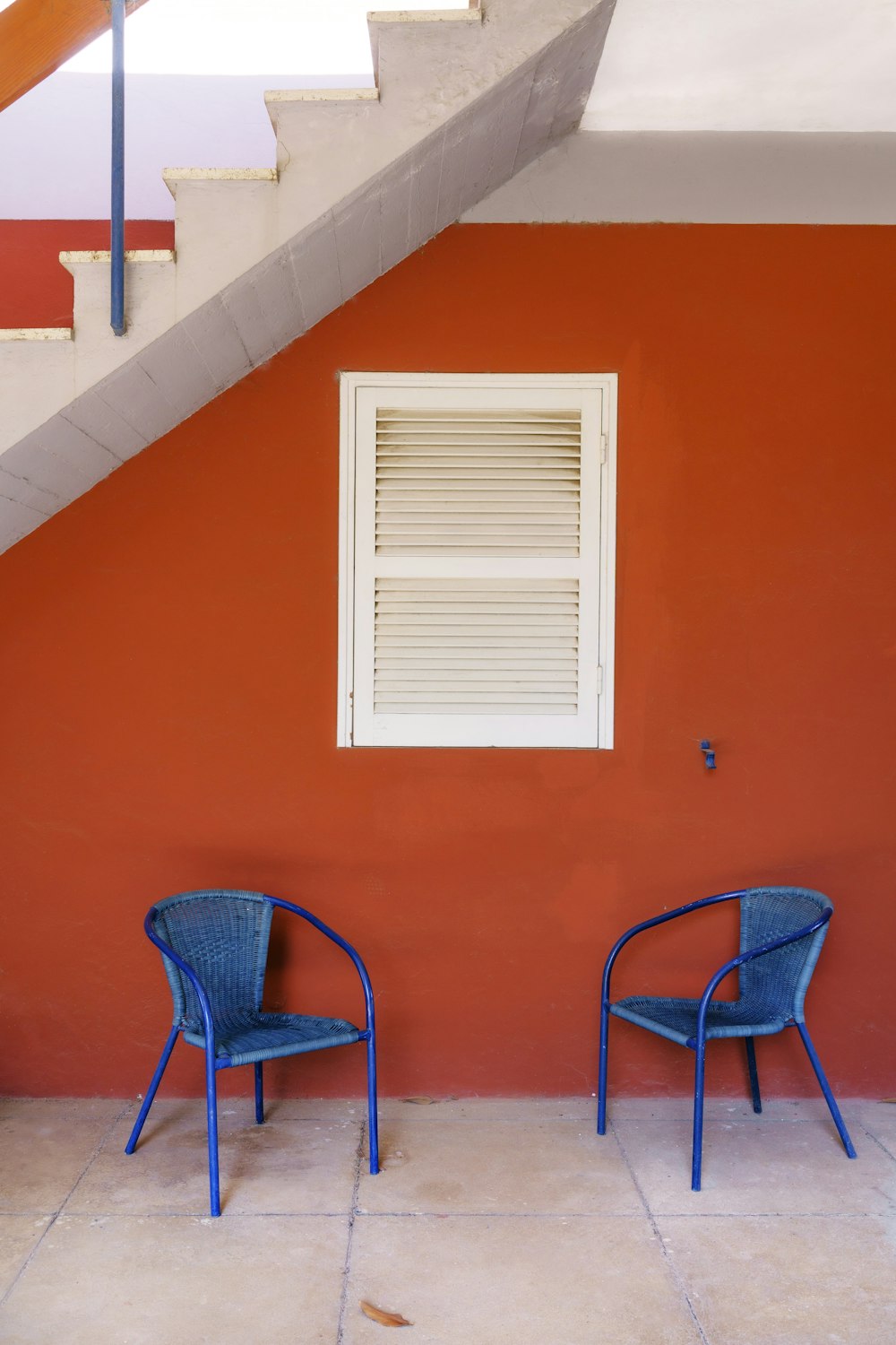 two blue chairs next to a building