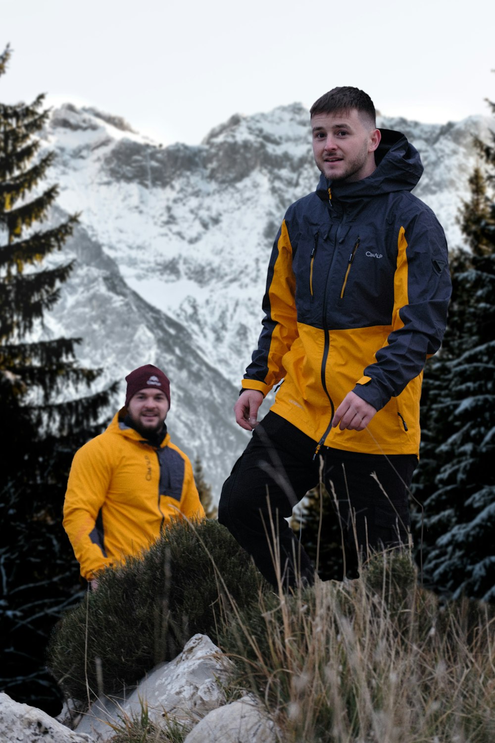 a couple of men standing on a mountain top