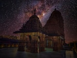 An ancient temple silhouette against digital starry universe backdrop