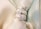 Three diamond rings with different cuts, including cushion, pear, and emerald, are elegantly displayed on a soft, light-colored fabric backdrop.