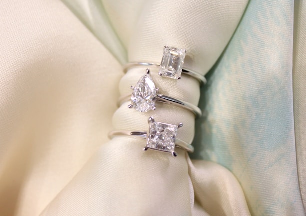 Three Lab-Grown Diamonds rings with different cuts, including cushion, pear, and emerald.