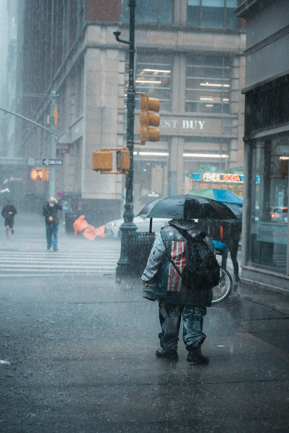 a couple of people walk under an umbrella