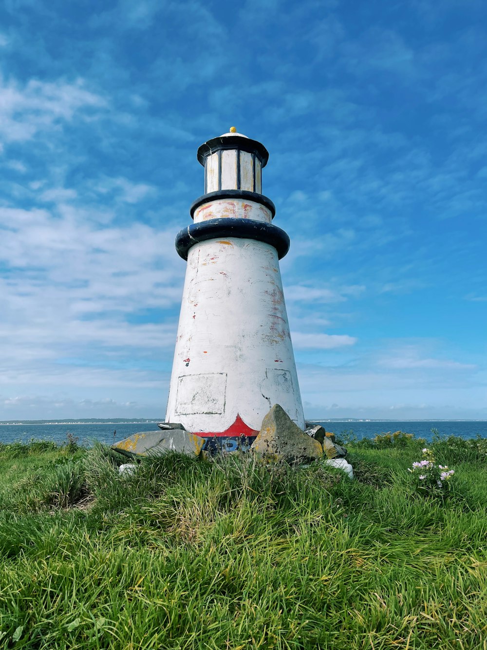 a lighthouse on a grassy hill