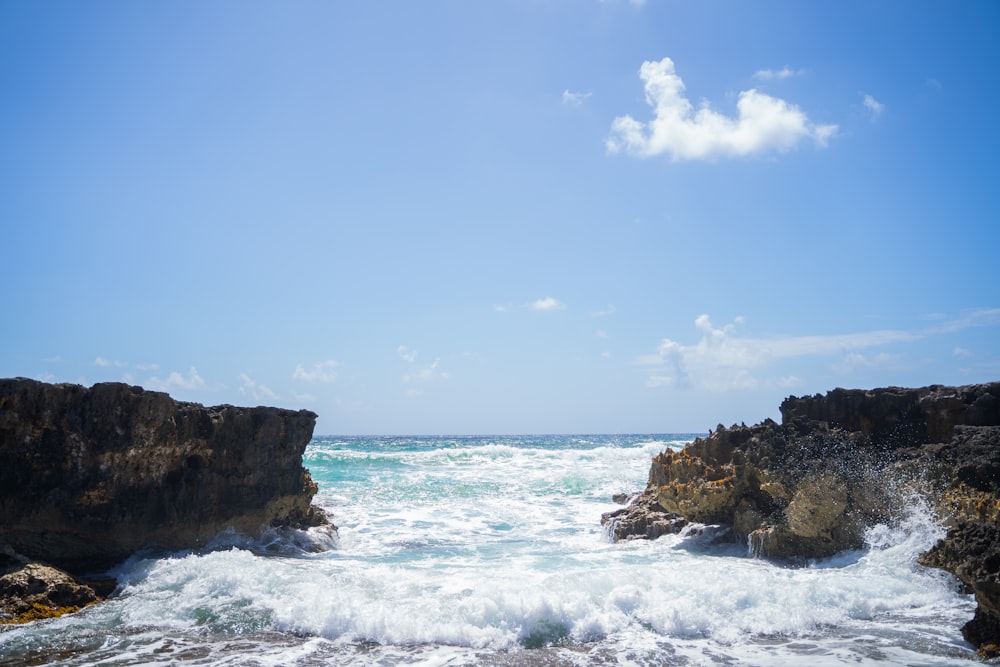 a rocky beach with waves crashing against the shore