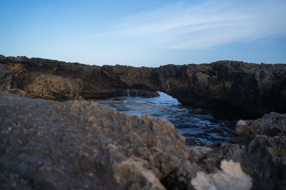 a rocky cliff with a body of water below