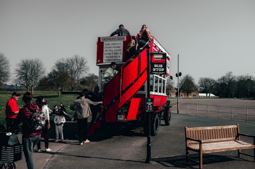 A group of travelers boarding a large 74-seater coach ready for a long-distance UK tour from Heathrow.