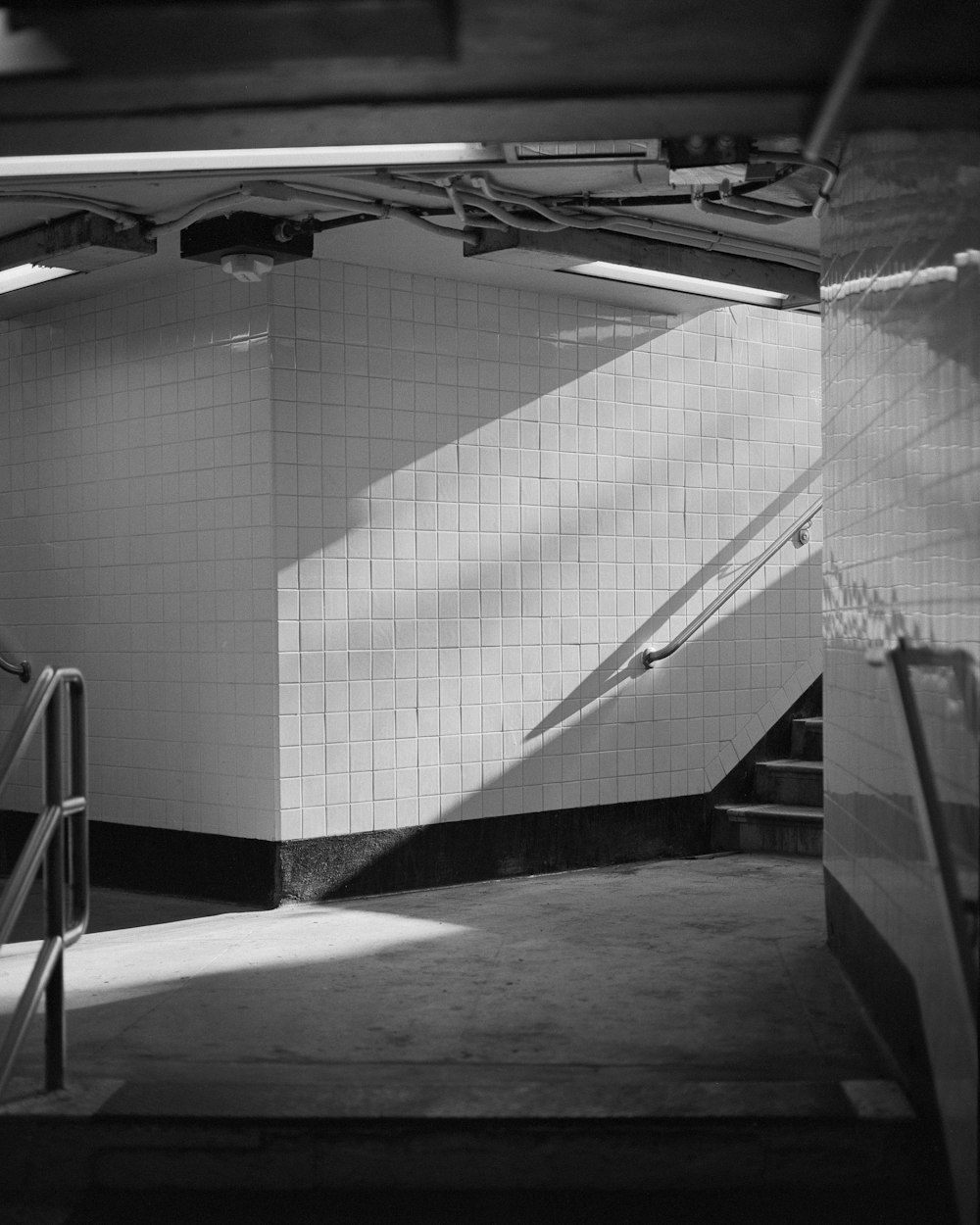 a room with a tile floor and a metal railing