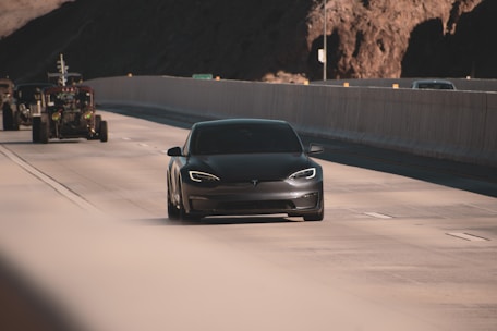 a black tesla model s car on a road