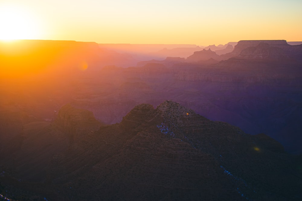 a landscape with hills and a sunset