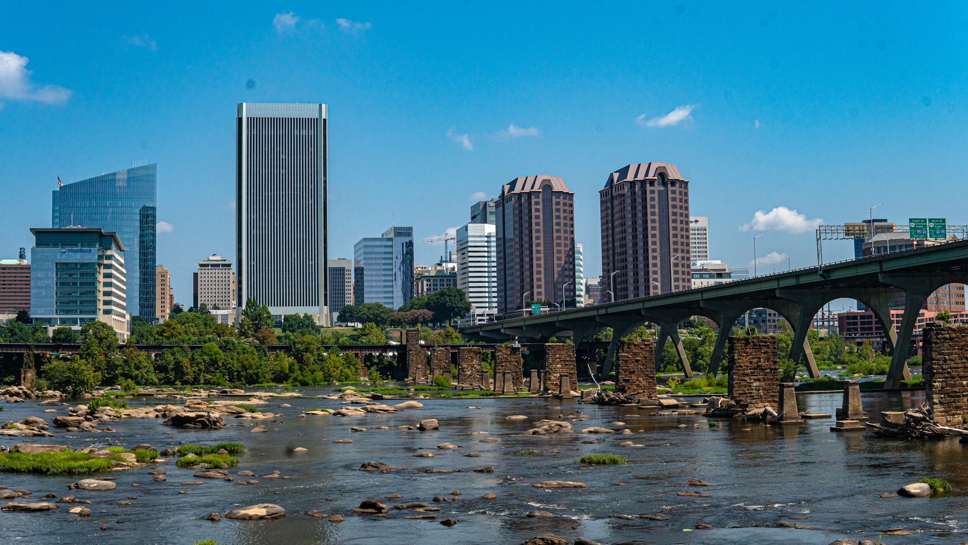 a bridge over a river with a city in the background