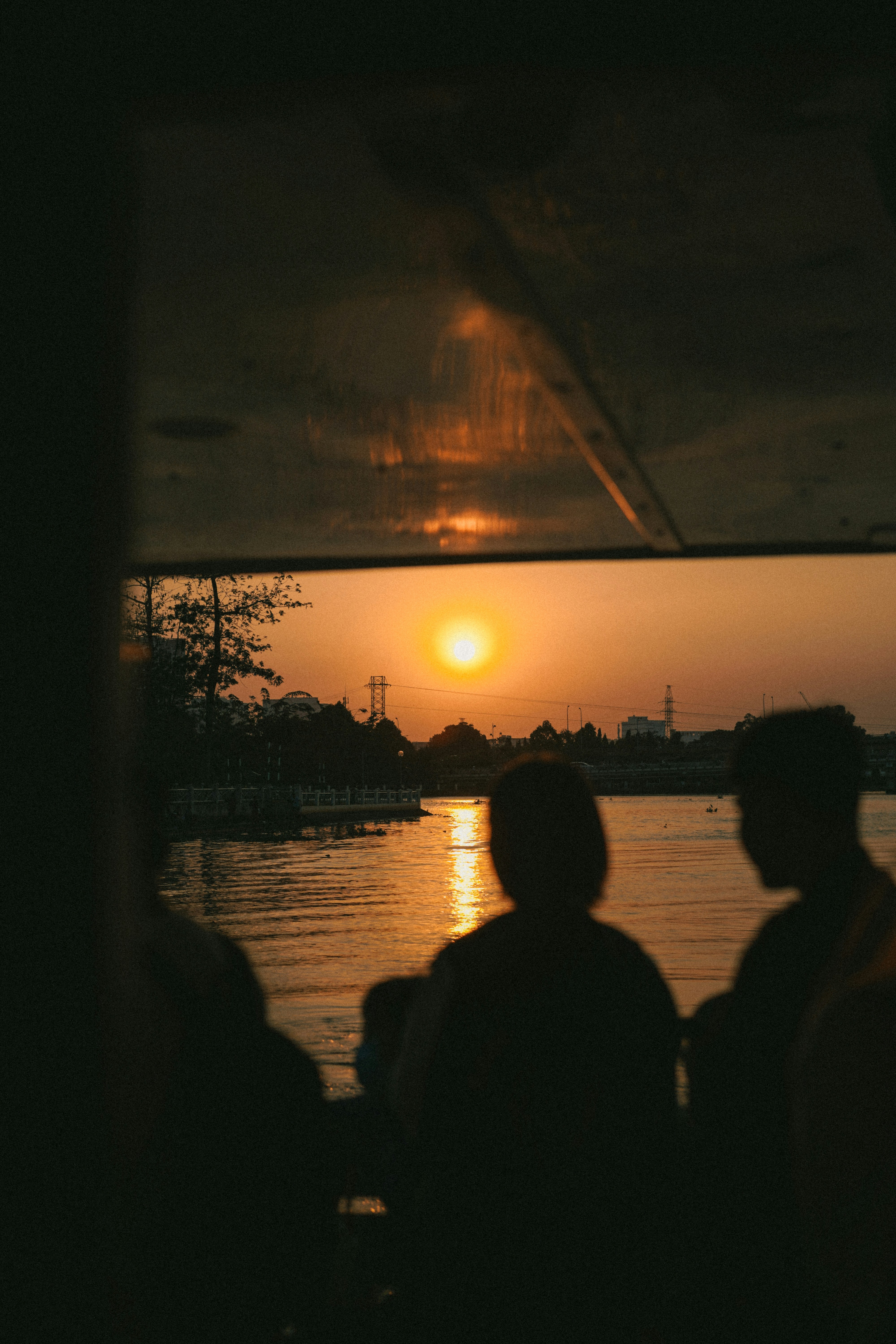 a group of people looking out a window at the sunset