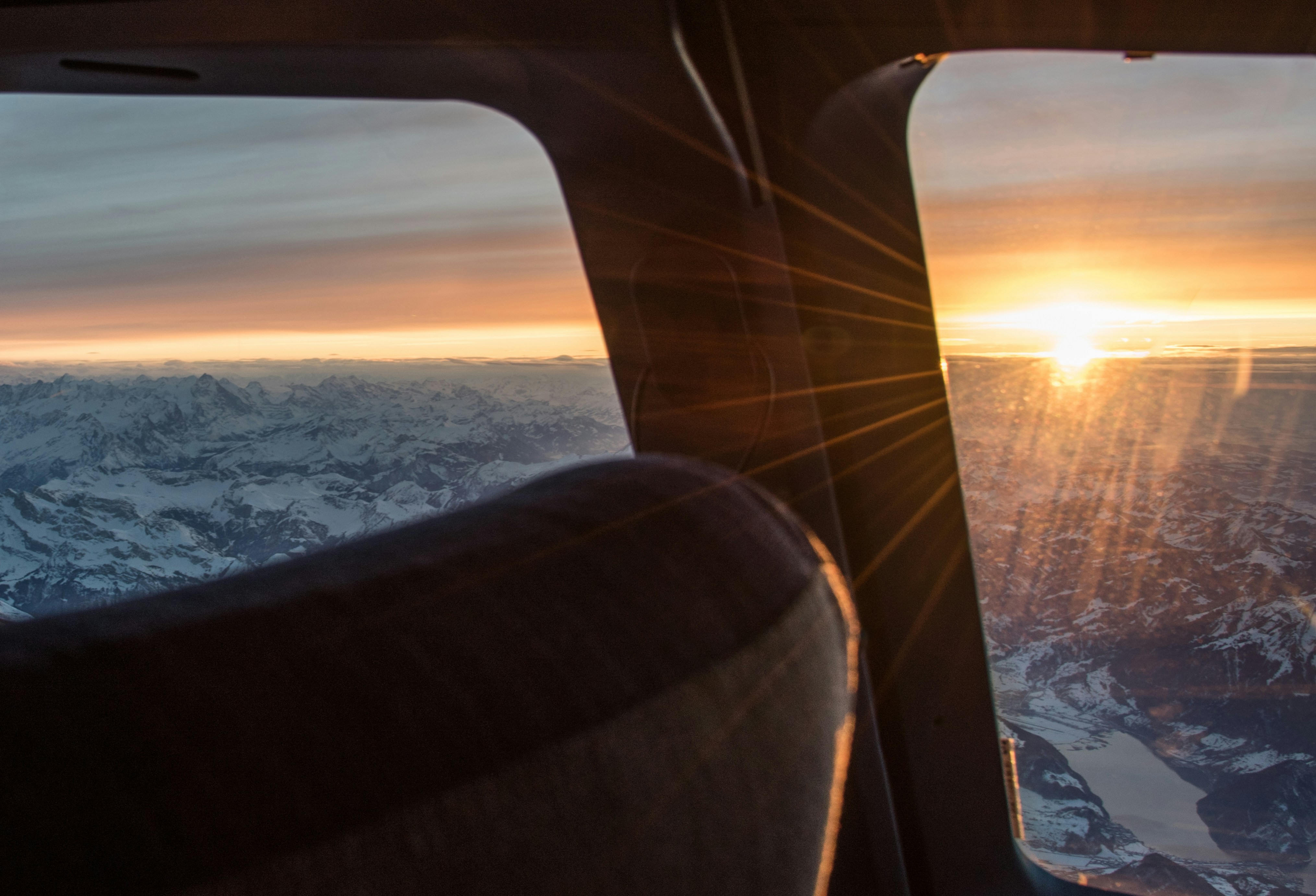 a view of the sun through a window of a snowy landscape, 
