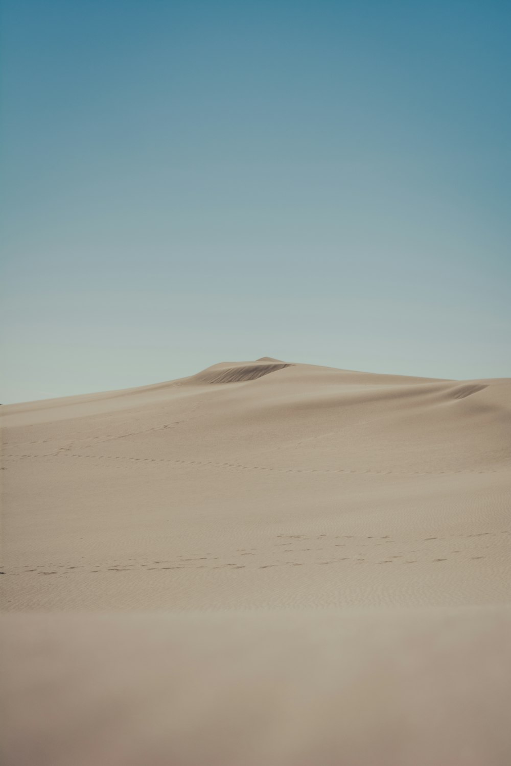 a sandy desert with a blue sky