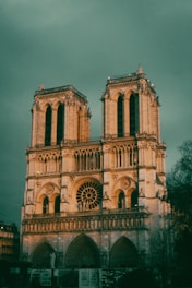 a large building with a clock tower with Notre Dame de Paris in the background