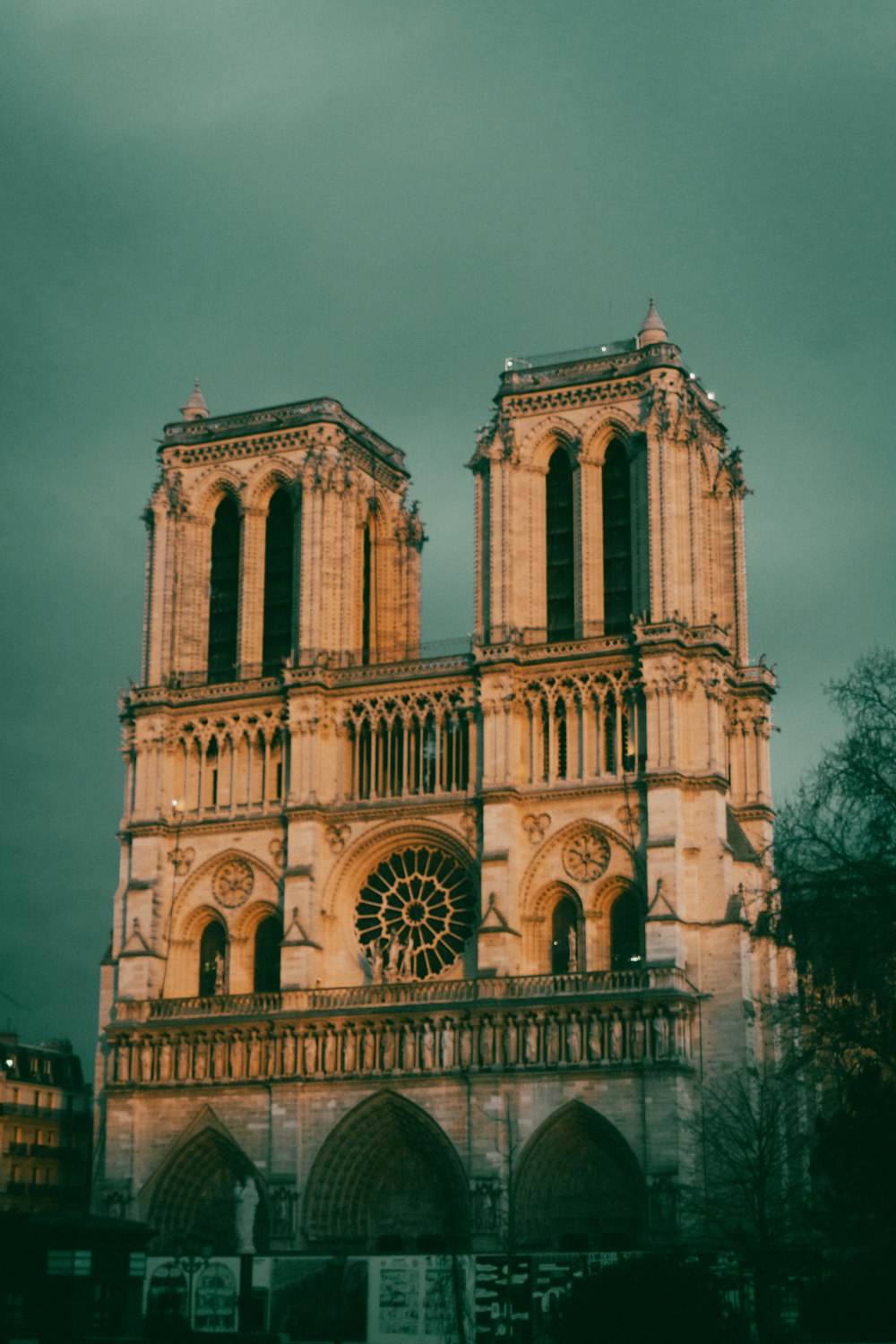un grande edificio con una torre dell'orologio con Notre Dame de Paris sullo sfondo