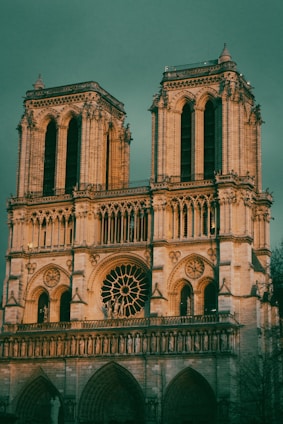 a large building with a clock on it with Notre Dame de Paris in the background