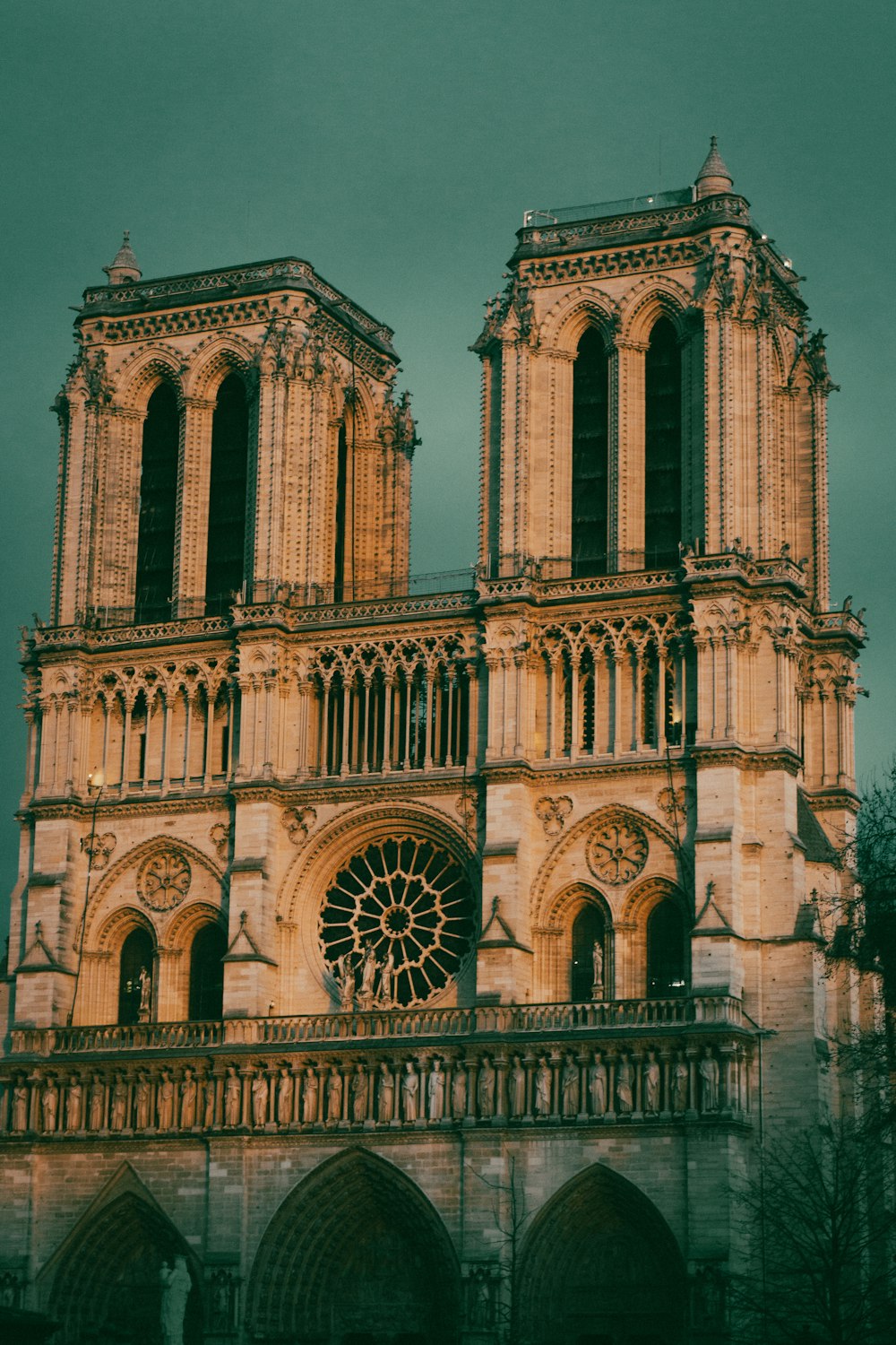 a large building with a clock on it with Notre Dame de Paris in the background