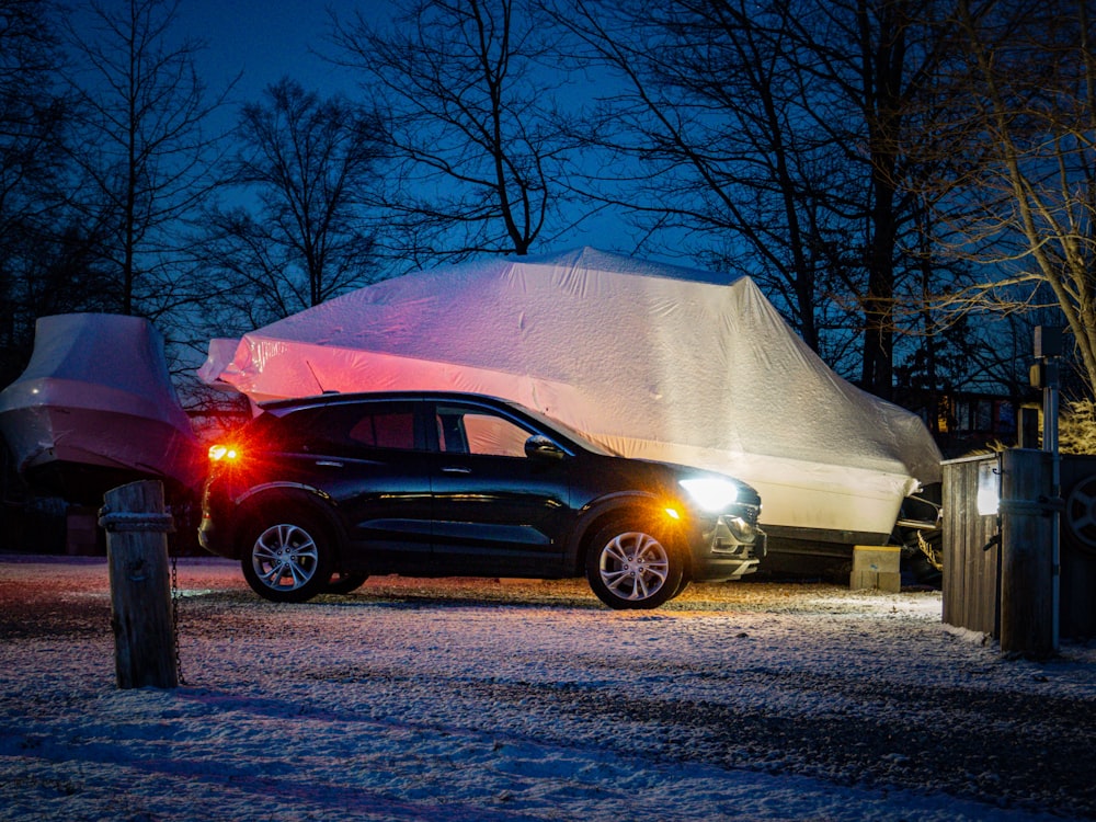 a car parked in front of a tent at night