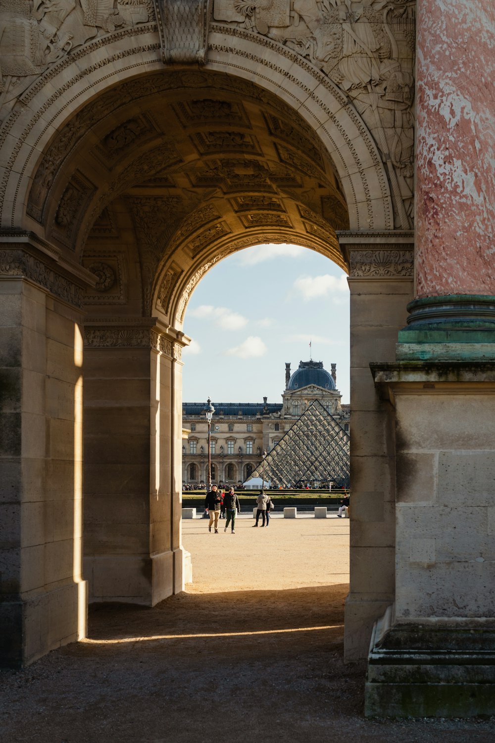 a group of people walking under a large archway