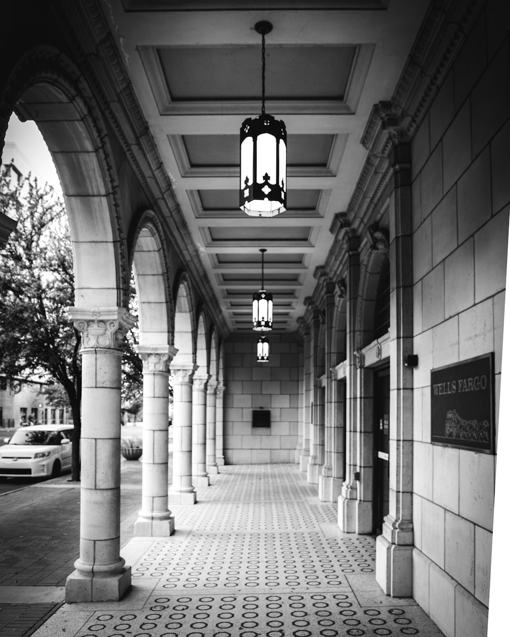 a brick walkway with a brick building and a car parked on the side