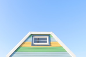 Exterior of a house with freshly painted bright blue facade and white window frames.