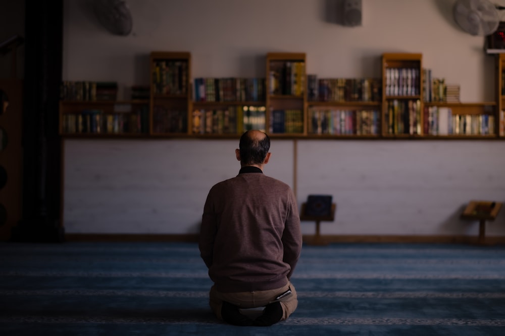 una persona in piedi davanti a una libreria