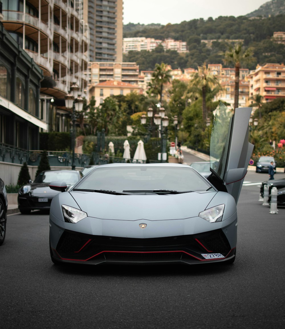 um carro esportivo branco estacionado ao lado de uma rua