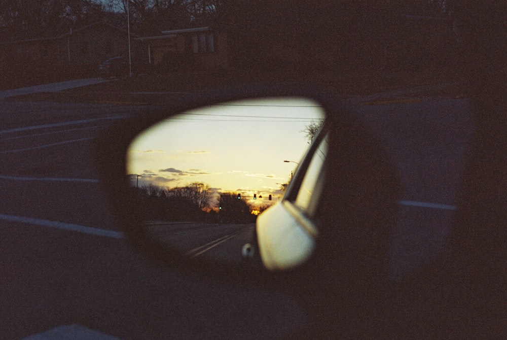 a car's side mirror showing a sunset