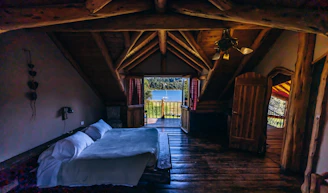 Cozy rustic cabin room with wooden walls and a large window showing a forest view