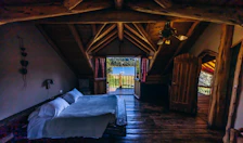 Cozy mountain lodge room featuring warm wooden accents and a private balcony.