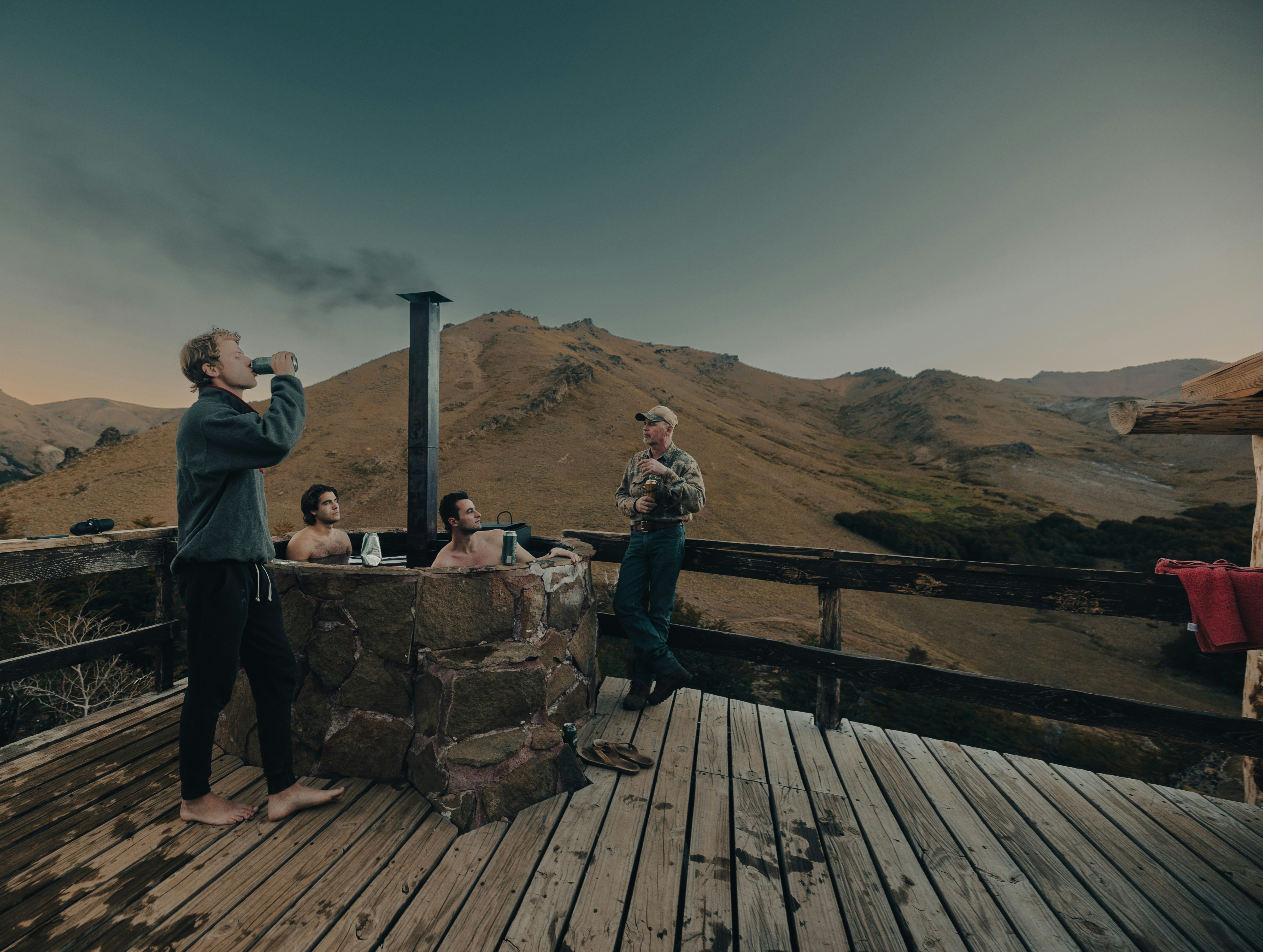 Guests relaxing outside an eco-lodge with adventure retreat insurance considerations in a mountain setting