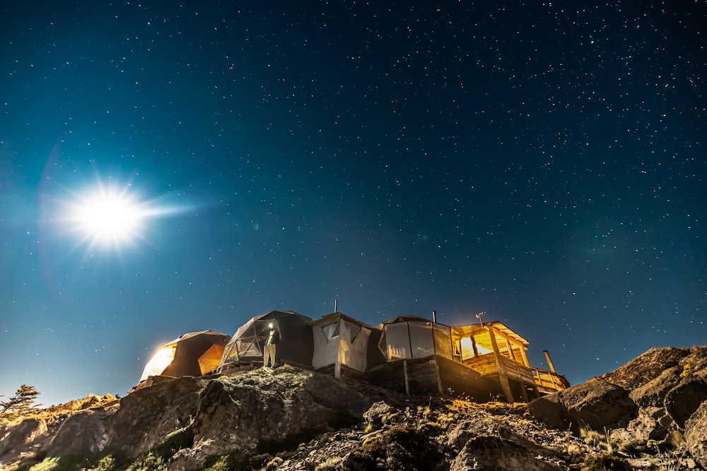 a group of trailers parked on a rocky hill under a starry sky