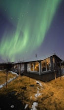 Cozy modern tiny house with large windows in a snowy landscape.