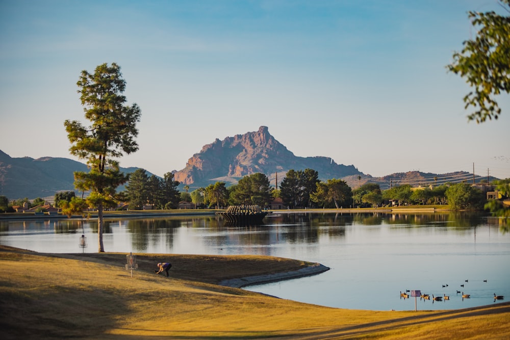 a body of water with trees and mountains in the background