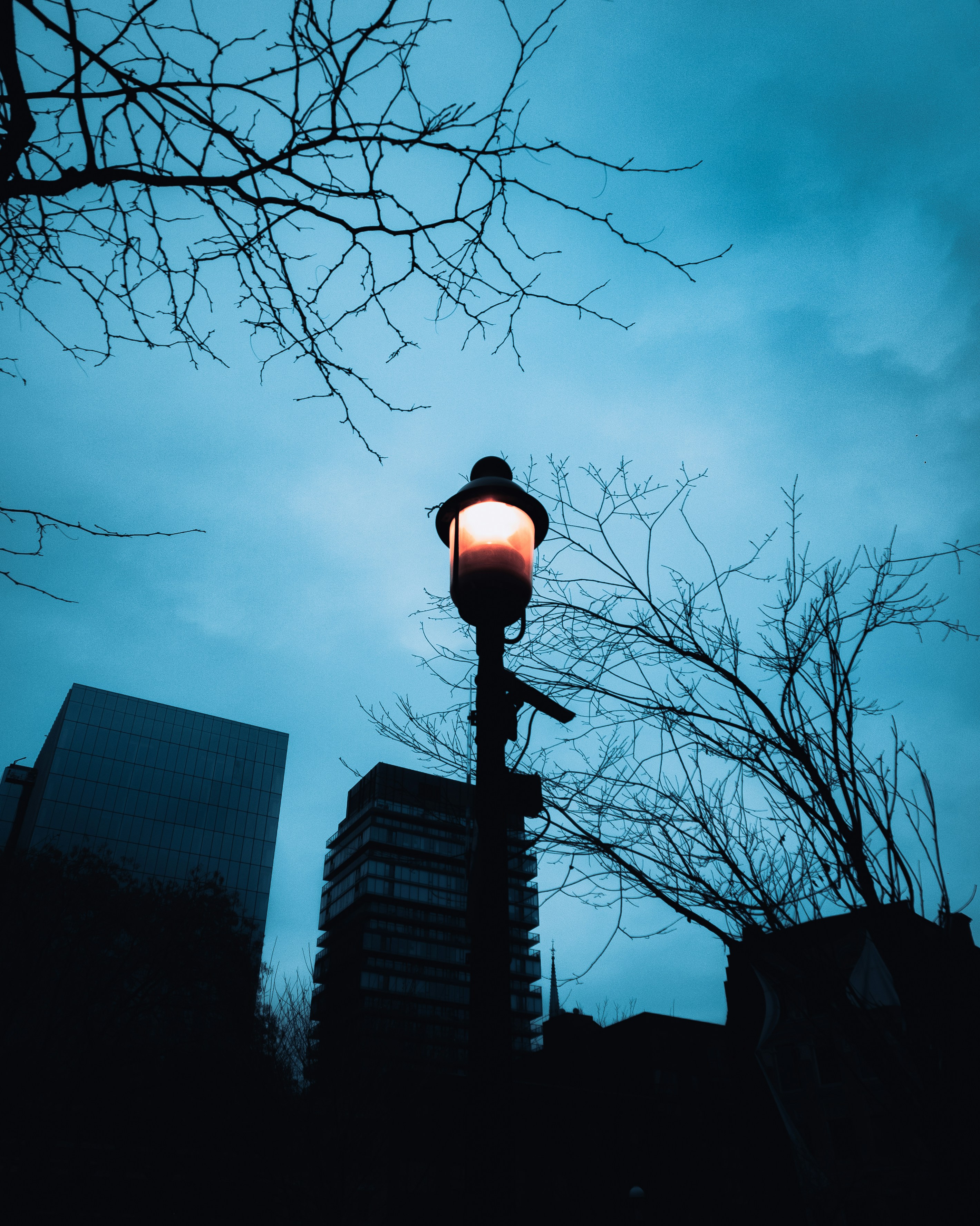 a light post with a light on top and buildings in the background