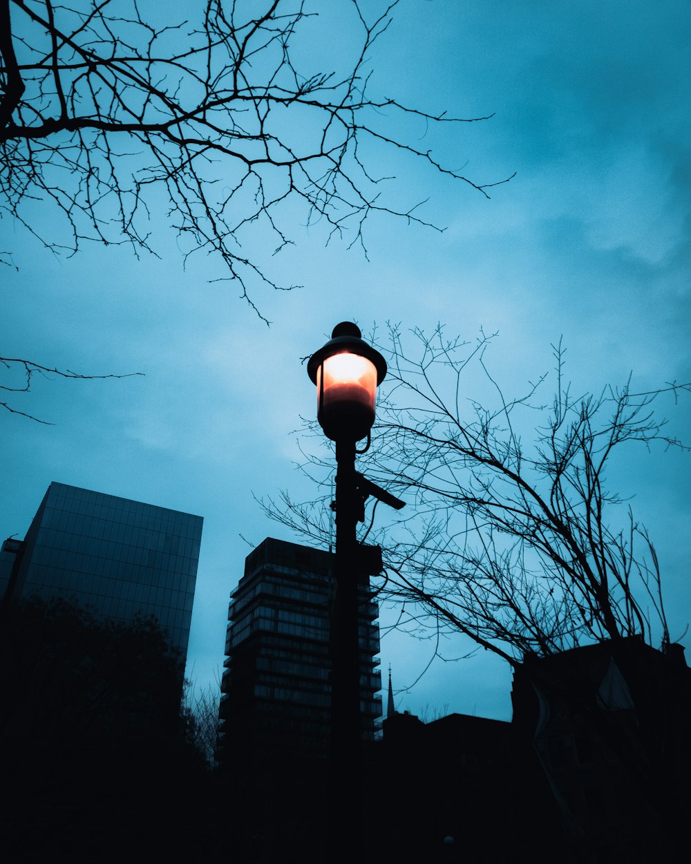 a light post with a light on top and buildings in the background