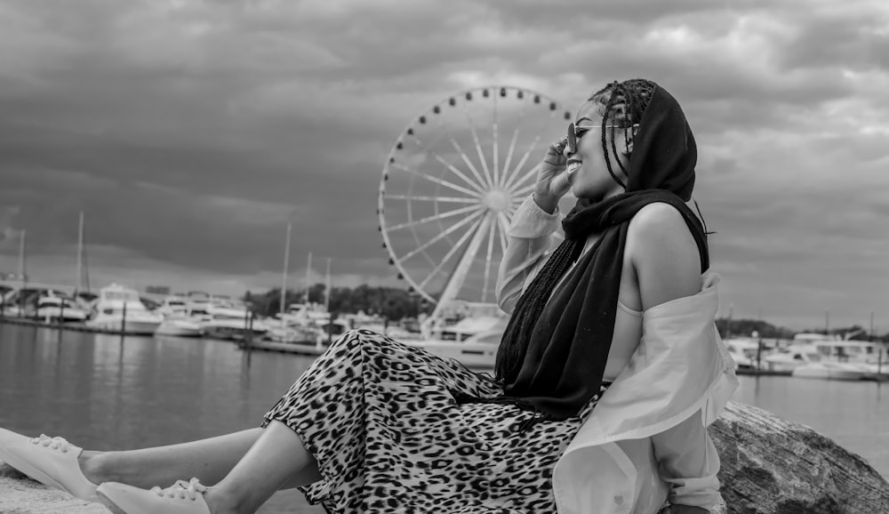 a person sitting on a rock with a large umbrella