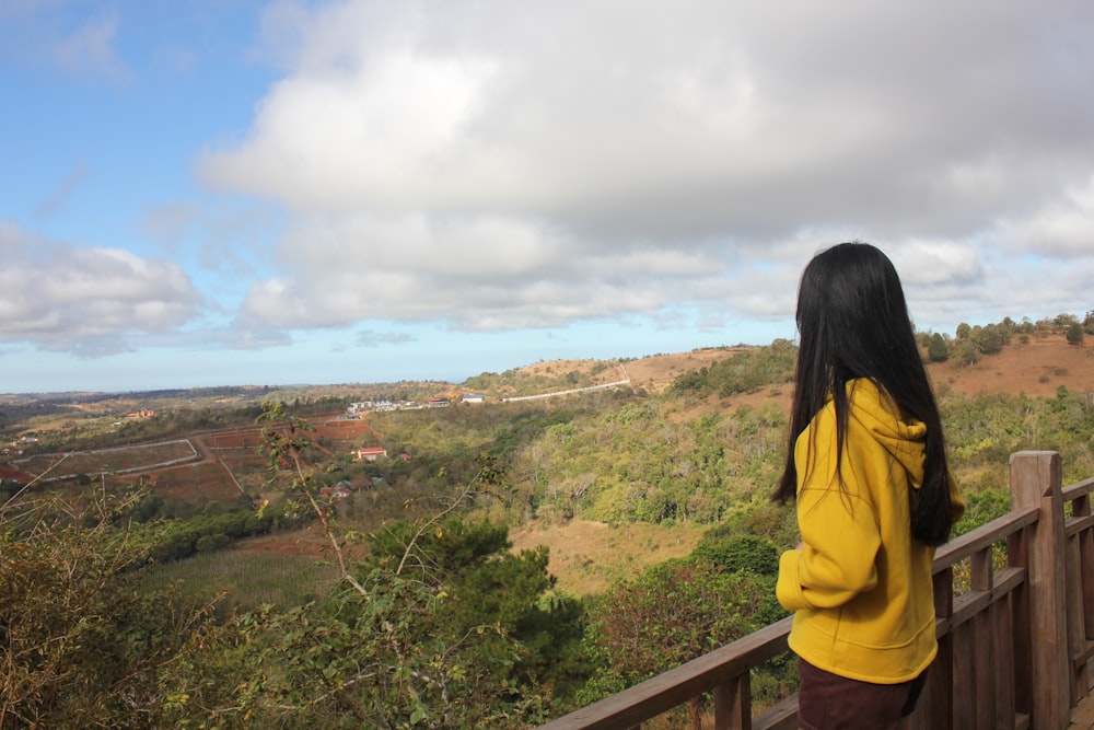 a person standing on a balcony overlooking a valley