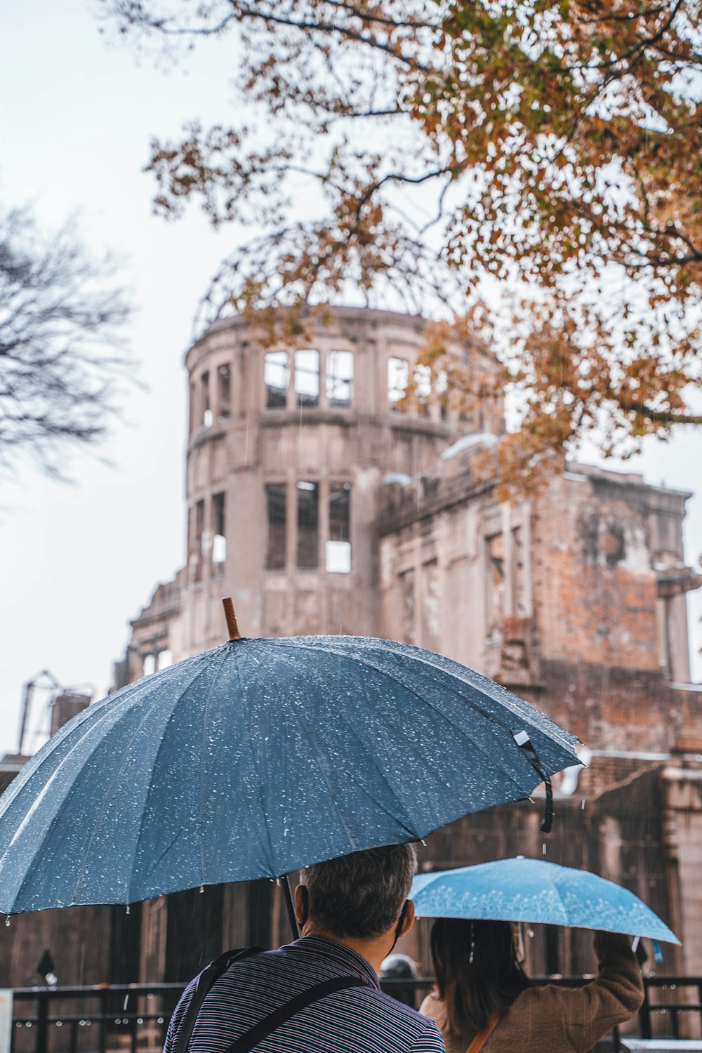 Menschen mit Regenschirmen vor einem Gebäude