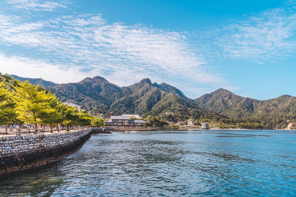 a body of water with a building and trees by it