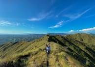 A group of friends hiking along a scenic trail, surrounded by rolling green hills.