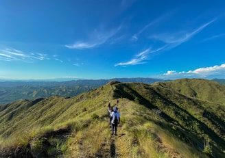 A group of friends hiking along a scenic trail, surrounded by rolling green hills.