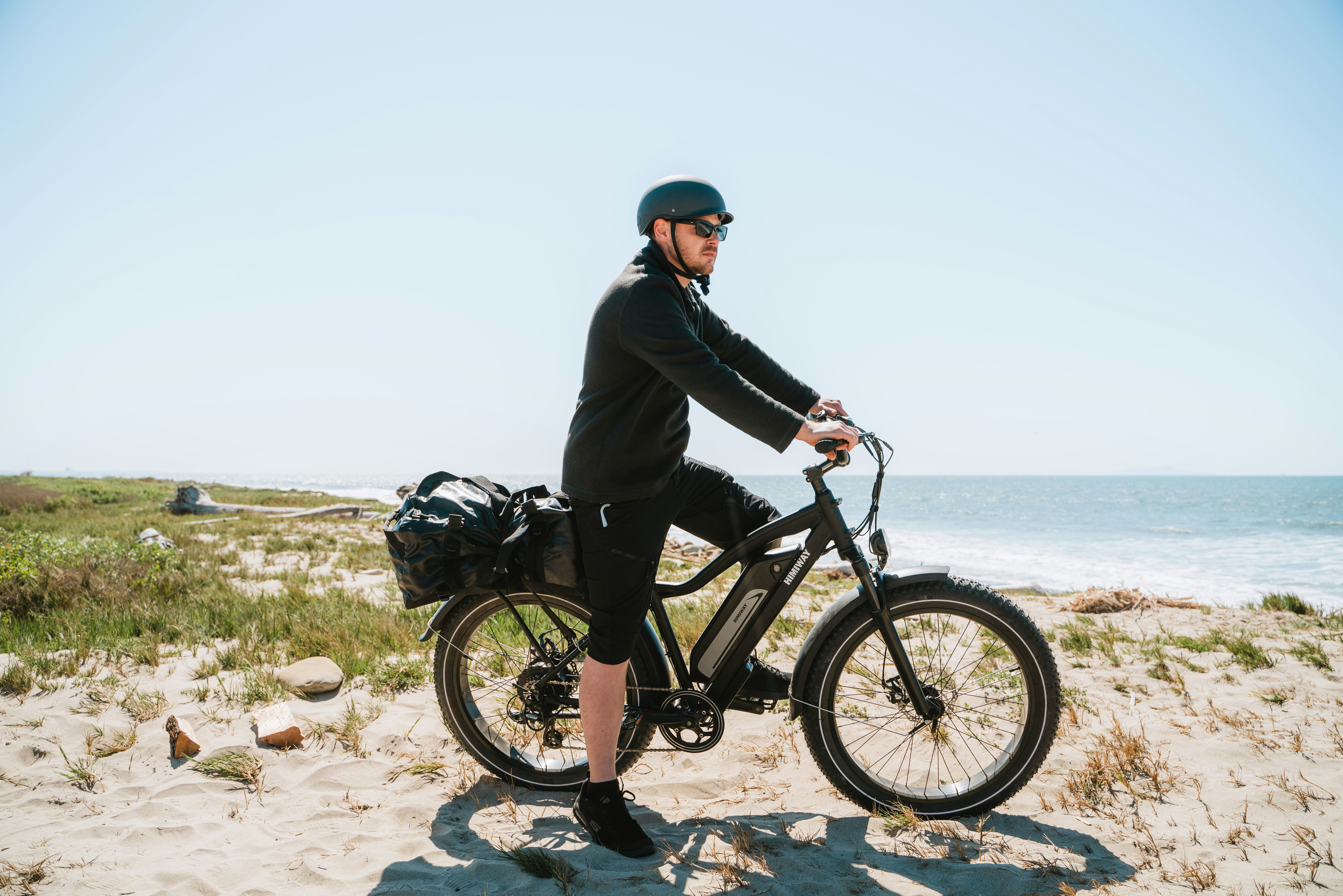 a man on a bicycle on a beach