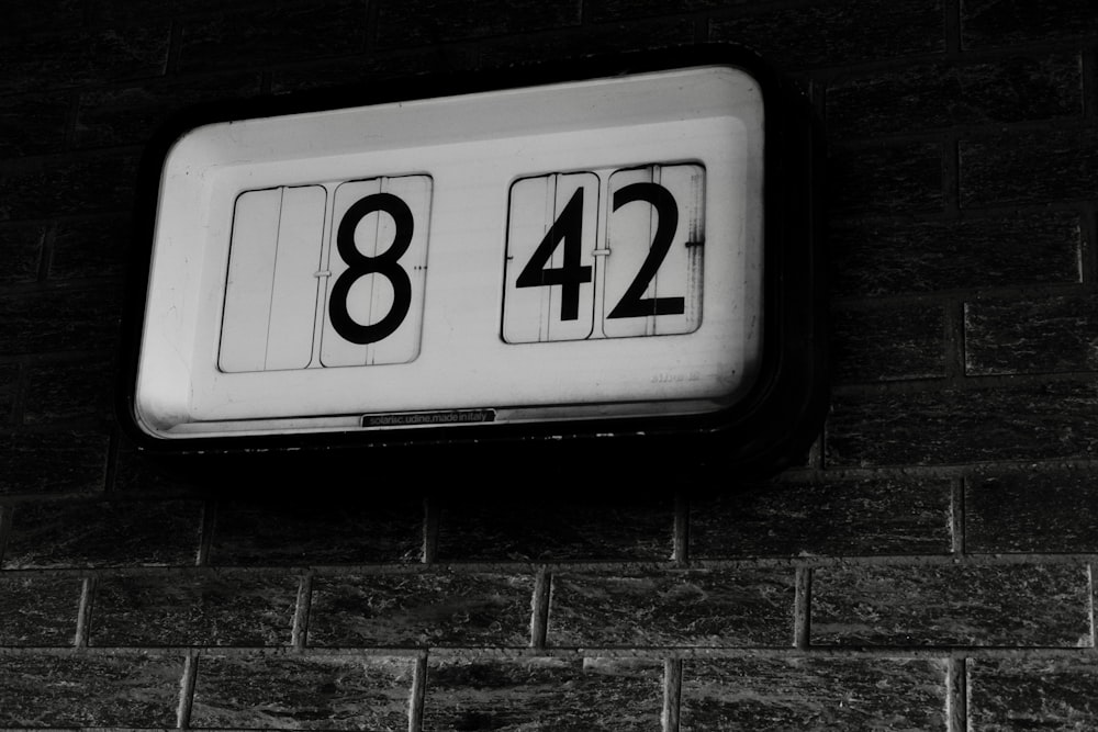 a white license plate on a brick wall