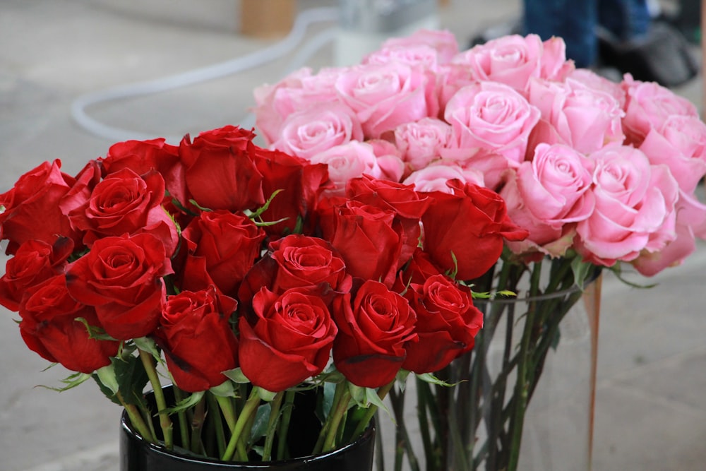 a vase of red and white roses