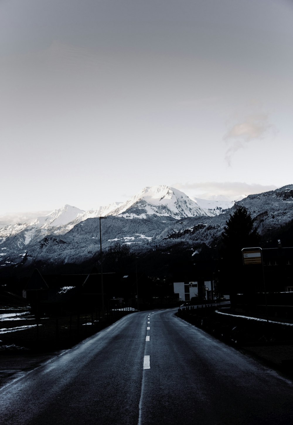 a snow covered road with a mountain in the background