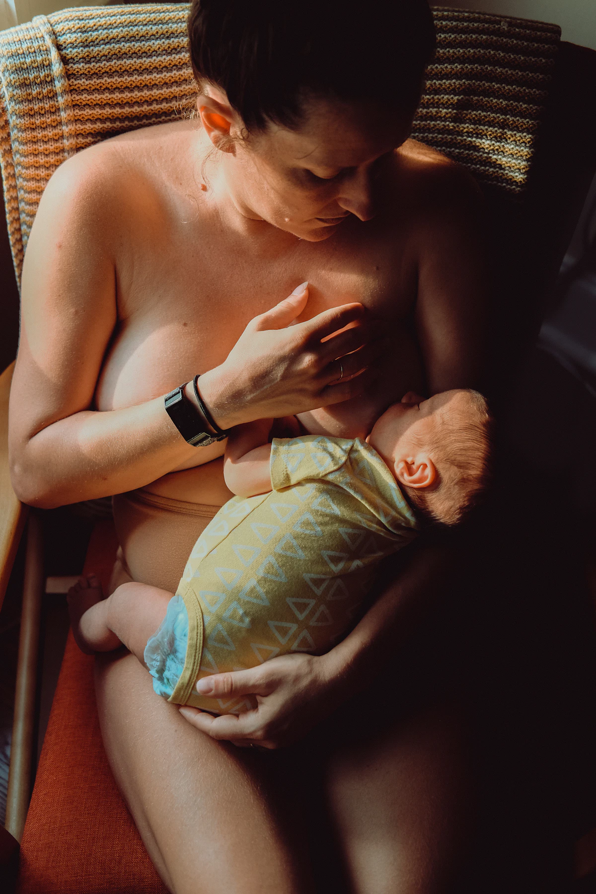 Parent tenderly holding their baby in warm, soft indoor lighting