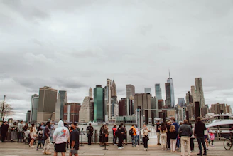 A diverse group of professionals in an office discussing job opportunities with city landmarks in the background.
