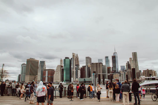 A diverse group of professionals in an office discussing job opportunities with city landmarks in the background.