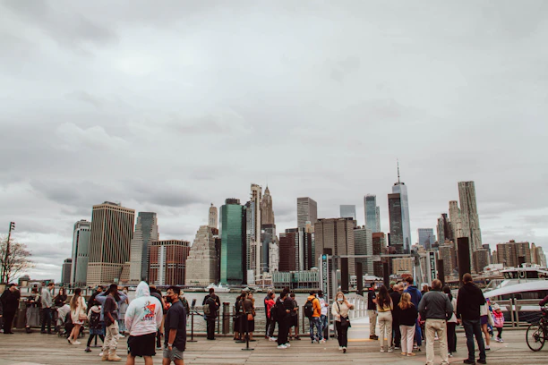 A diverse group of passionate volunteers collaborating outdoors with city skyline in the background.